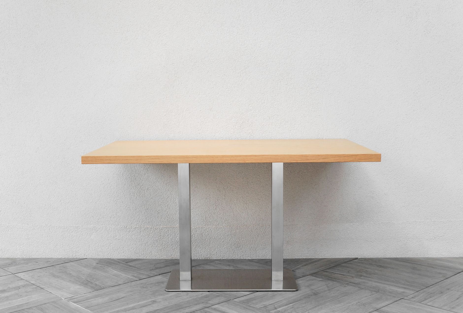 Minimalistischer Holztisch vor weißer Wand